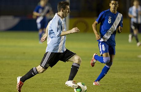 Argentinská superhvzda Lionel Messi (vlevo) s míem, sledován guatemalským