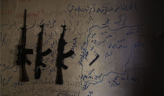 Zeď v jednom z domů syrských povstalců v Aleppu, kde visí tři zbraně a na zdi