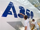 Zamstnanci airbusu dokonují logo letounu Airbus A350 XWB na jeho trupu.
