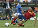 panlský fotbalista Thiago Alcántara se snaí zastavit prnik Itala Lorenza