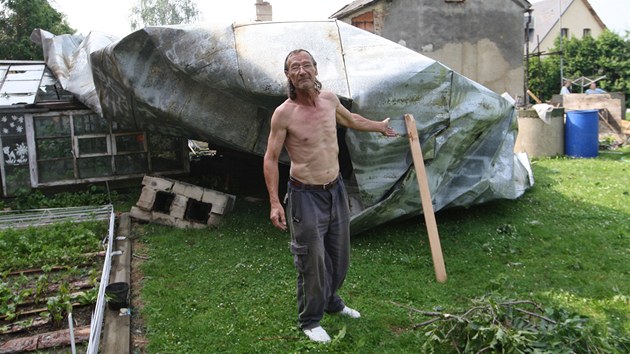 Střecha v zahradě. Vlastimil Tihelka ukazuje ve své zahradě střechu, kterou vichr vyrval ze sousedova domu. (19. června 2013)