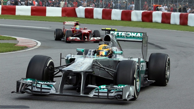 S JEDNM FERRARI SI PORADIL. Lewis Hamilton s vozem Mercedes prv pedjel o cel kolo Felipeho Massu s Ferrari.