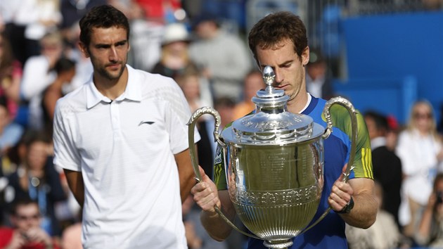 S POHREM. Britsk tenista Andy Murray si pozorn prohl trofej, kterou v nedli vyhrl na turnaji v Londn. Zpovzdl ho sleduje poraen finalista Marin ili z Chorvatska.