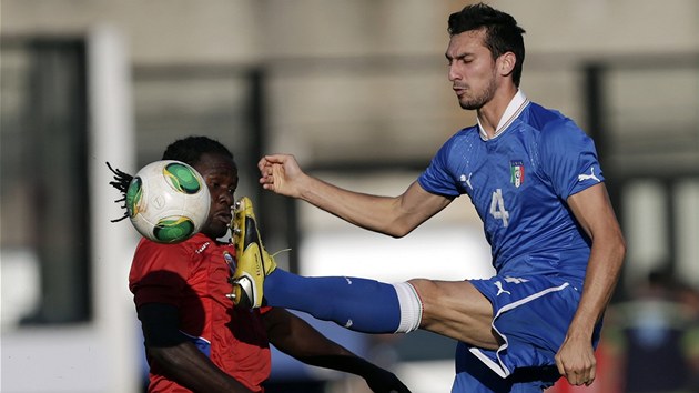 Italsk fotbalista Davide Astori v nebezpenm souboji s Kevinem Filsem Belfortem z Haiti.  