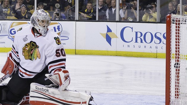 POKOEN. Chicagsk glman Corey Crawford sleduje puk ve sv sti. Pekonal ho Daniel Paille z Bostonu.