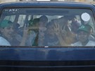 Chlapci mávají z autokaru, který je odváí dom z tábora organizovaného Hamásem
