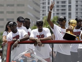 Chris Bosh svírá trofej pro vítze NBA. 