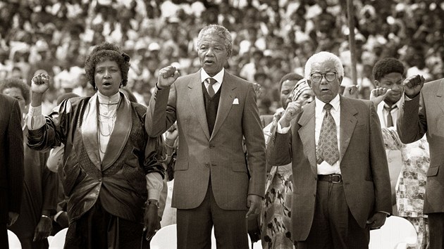 KONTROVERZN WINNIE. Mandela se svou druhou manelkou Winnie bhem shromdn ve mst Soweto v roce 1990. Winnie je jednou z nejkontroverznjch postav JAR. Zatmco ji jedni oznauj za "Matku nroda", dal j zloe. Bhem apartheidu byla usvdena z nosu trnctiletho chlapce, kter byl pozdji nalezen ubit k smrti. Po zaveden demokracie se ocitla u soudu znovu kvli podvodm. S Mandelou se rozvedli.