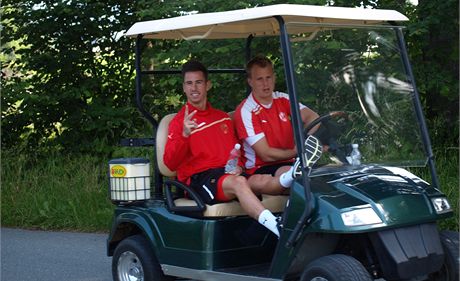 Milan Petrela (vlevo) pijídí na trénink na golfovém vozítku.