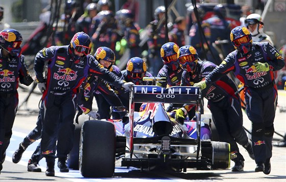 Vz Red Bull Mark Webbera bez zadní pneumatiky. Mechanici ho zatlaují zpátky