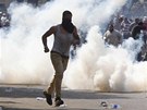 Jeden z píznivc Mursího utíká od granátu se slzným plynem v Káhie (5.