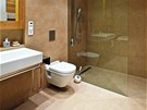 Velká koupelna má stny i podlahu z velkoformátových desek 300 × 100 cm, spáry
