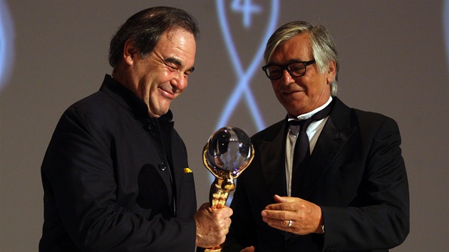 Oliver Stone pebr od prezidenta festivalu Jiho Bartoky cenu na 48. ronku filmovho festivalu v Karlovch Varech (6. ervence 2013)