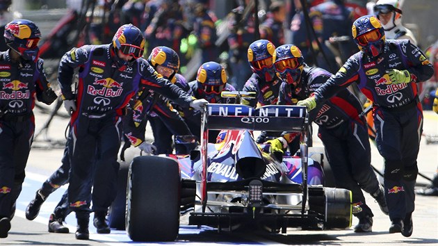 Vz Red Bull Mark Webbera bez zadn pneumatiky. Mechanici ho zatlauj zptky do boxovho stn.