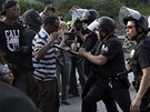 Policice hlídá dav lidí, který se seel, aby vyjádil nesouhlas s osvobozením