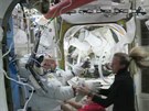 Kosmonautka Karen Nybergová pomáhá italskému kolegovi ze skafandru, kdy musel...