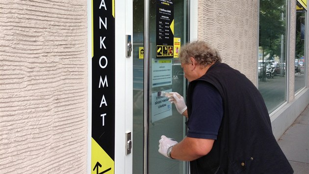 Policejn technik snm otisky ze vstupnch dve pepaden poboky Raiffeisen Bank v Nitransk ulici v Praze (12.7.2013)