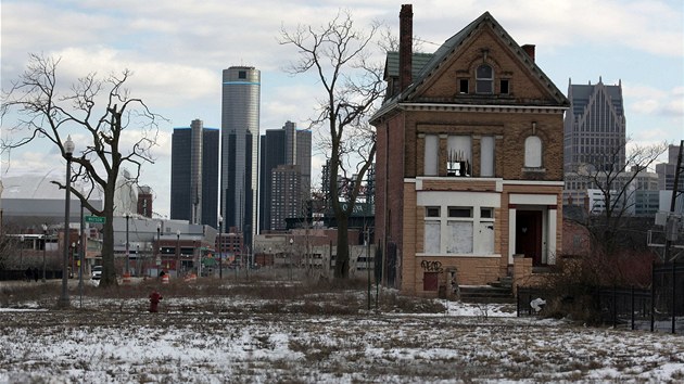 Oputn dm v kdysi iv tvrti Brush Park na pozad mrakodrap detroitskho centra. (Detroit, 20. bezna 2013)