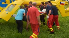 Hasi�i a záchraná�i nakládají do vrtulníku mladou �enu, která se popálila, kdy�...