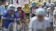 Chris Froome (ve lutém) dokonuje 13. etapu Tour de France v hlavním pelotonu.