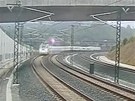 Zábr z bezpenostní kamery - vlak rychle vjídí do oblouku trati u msta...