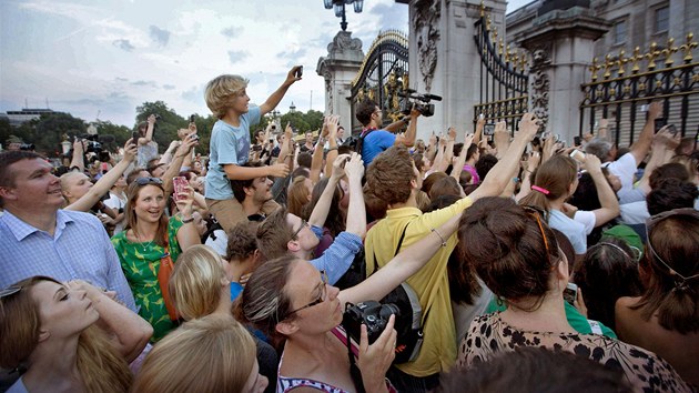 Britov ped Buckinghamskm palcem se sna vyfotit oznmen o narozen nslednka trnu. (22. ervence 2013)