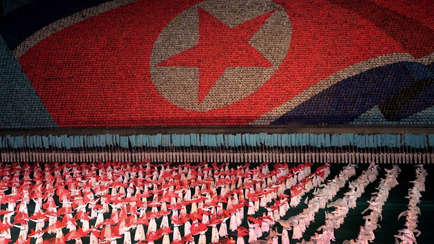 ZA SOCIALISMUS. Severokorejci cvi na Arirangu v pipravench sestavch, zatmco na pozad mn dal lid tematick obrazce. Na tomto snmku vlaje vlajka KLDR: 