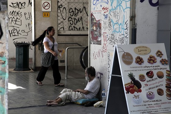 Bezdomovec ebrá u vchodu do metra ve tvrti Monastiraki v Aténách.