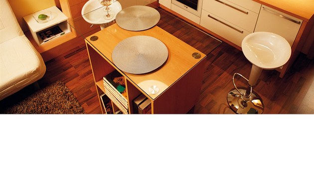Centrálním prvkem malé kuchyňky s obývací částí
je multifunkční kostka se skleněnou deskou.