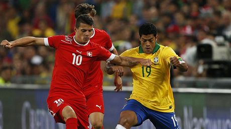 výcarský fotbalista Granit Xhaka (vlevo) v souboji s Brazilcem Hulkem.