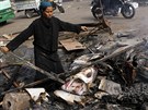 Egypanka prohledává spálenit na káhirském námstí Nahda. Na zemi jsou...