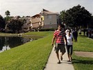 Turisté procházejí kolem jezírka v letovisku Summer Bay Resort u Orlanda, kde