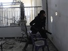 Voják Syrské svobodné armády hledá cíl skrze díru ve zdi ve mst Dajr az-Zaur