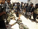 Syrtí povstalci ohledávají tlo vládního vojáka ve mst Chanasír nedaleko...