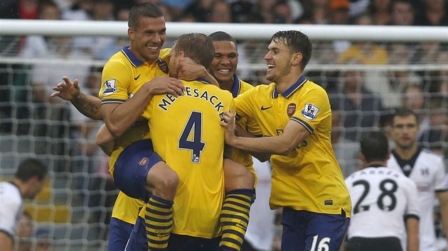 Fotbalist Arsenalu oslavuj trefu Lukase Podolskho (vlevo).