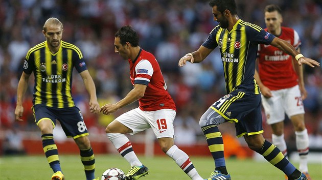 Santi Cazorla (uprosted) z Arsenalu prochází mezi Selcuk Sahinem (vpravo) a...