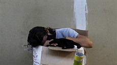 Bezdomovec s kokou uvnit papírové krabice v turistické oblasti Plaka v...