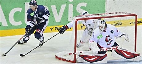 Liberecký hokejista Pospíil se tlaí ped pardubického gólmana Martina Riku.