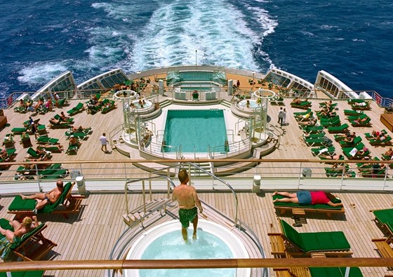 Pohled ze zadní paluby Queen Mary 2 přes bazény na volné moře