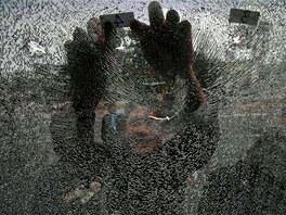 GUMOVÉ PROTESTY. Policista zkoumá rozbité sklo policejního autobusu po stetech...