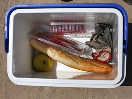 Food lies at the bottom of Jorge Ibanez's cooler as he takes a break from...