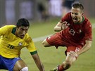 Portugalský reprezentant Joao Pereira (21) padá po faulu Paulinha z Brazílie.