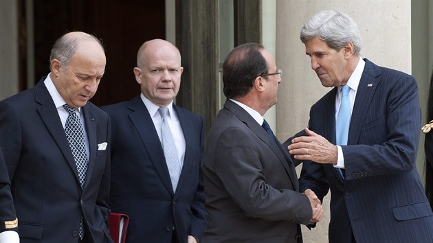 Americk ministr zahrani John Kerry (pln vpravo) si pots rukou s francouzskm prezidentem (druh zprava). Spolen s fem francouzsk diplomacie Laurentem Fabiem (pln vlevo) a britskm ministrem zahrani Williamem Haguem jednali v Pai o een syrsk krize (16. z 2013).