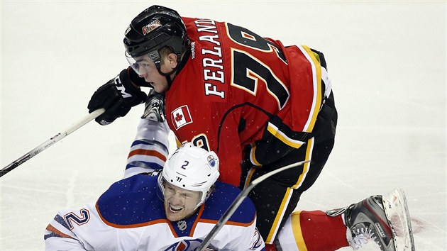 Jeff Petry (dole) z Edmontonu p pod nporem ' Michaela Ferlanda z Calgary.