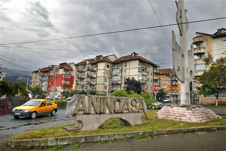 A car drives past a town sign at a road intersection in Aninoasa, 330 km (202...