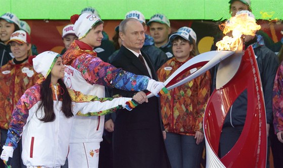 Vladimir Putin zapaluje na Rudém námstí olympijský ohe. (Moskva, 6. íjna...