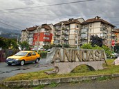 A car drives past a town sign at a road intersection in Aninoasa, 330 km (202...