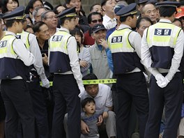 Policisté dohlíí na poádek bhem vojenské pehlídky k 65. výroí Dne...