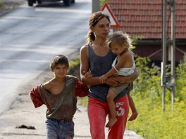 A woman walks with children along a road in Aninoasa, 330 km (202 miles) west...