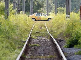 A cab crosses a railroad track in Aninoasa, west of Bucharest July 30, 2013. If...